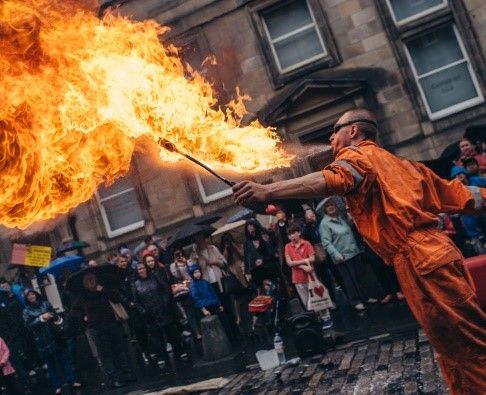 Motiv: Edinburgh-Fringe. Feuerspucker auf der Straße mit Kopfsteinpflaster